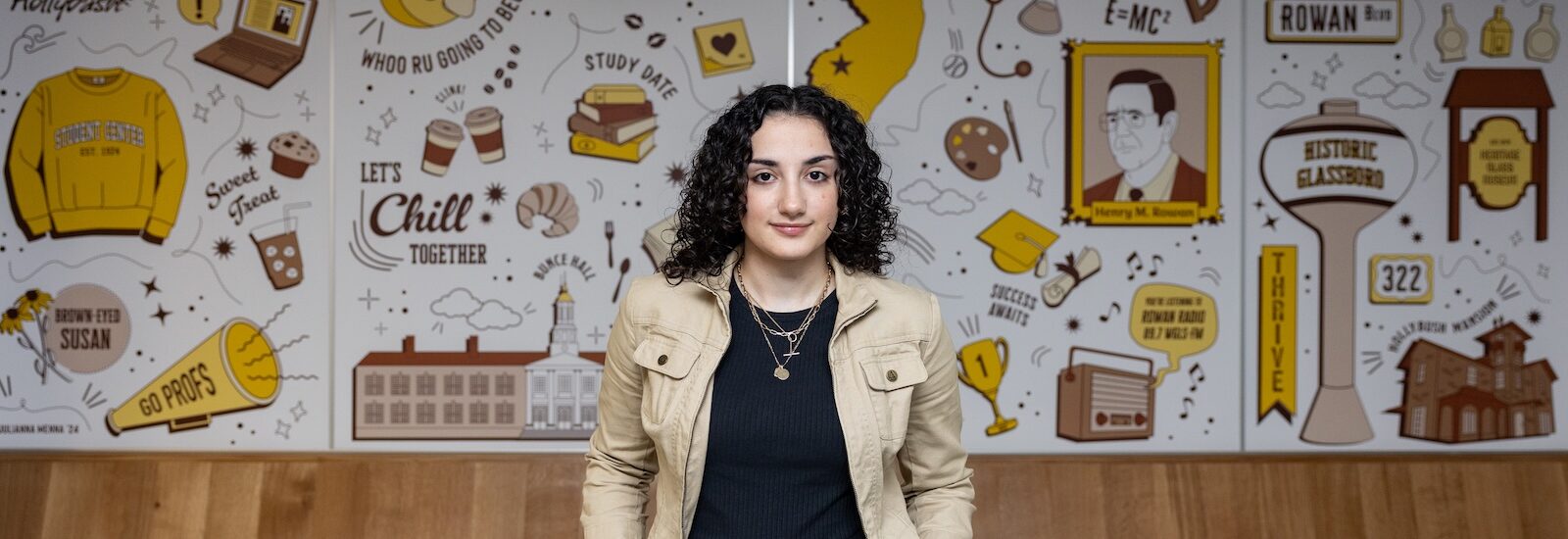 Julianna stands in front of her mural in Rowan's Student Center.