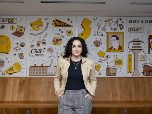 Julianna stands in front of her mural in Rowan's Student Center.