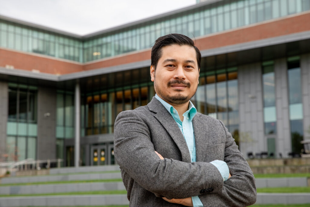 MBA graduate standing confidently outside a university building, representing leadership readiness and career advancement after earning an MBA.