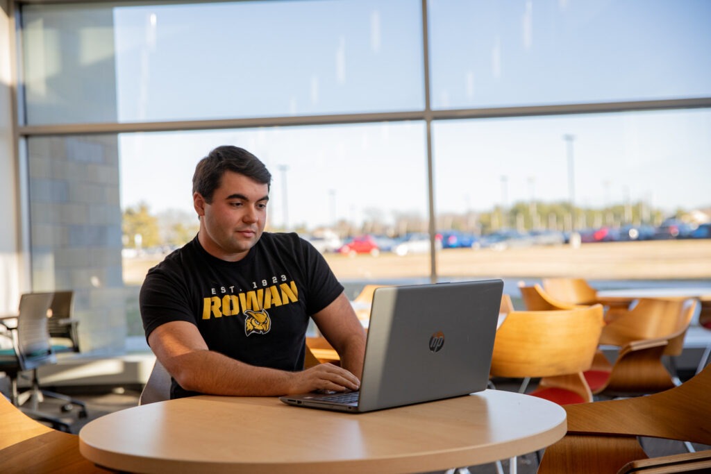 Male student completing online coursework on computer for early childhood special education certificate.
