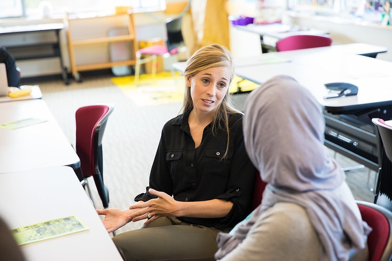 Special ed teacher who pursued an inclusive education master's collaborating with a student in the classroom.