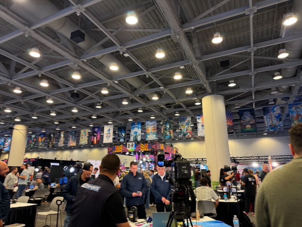 An overview of the busy nature of Media Row, with media and interviews happening all around, from the perspective of where Julia and her fellow Rowan sports communication and media students were standing. 