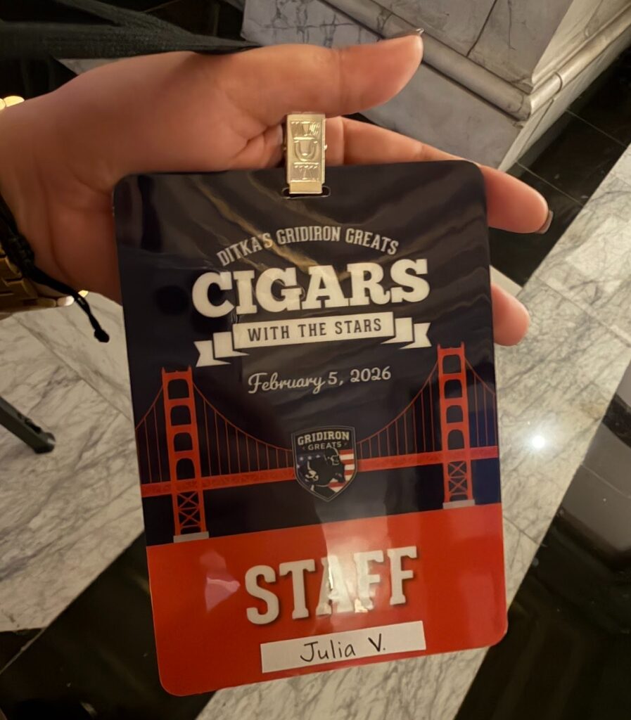 A close up of Julia's VIP badge for the Cigars with the Stars pre-Super Bowl event, which is branded for the event and has the word "STAFF" on it with her name. 