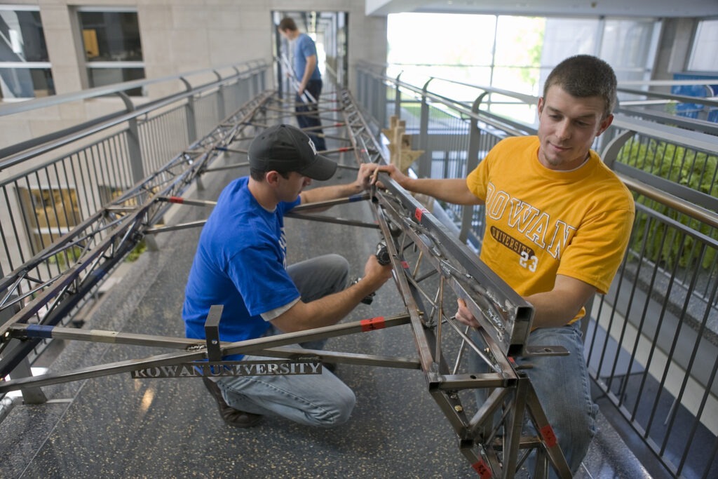 Three engineering students building in Rowan's engineering clinic.