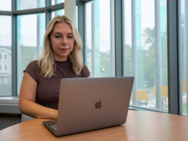 Student using a laptop while studying in an online college program at Rowan University.
