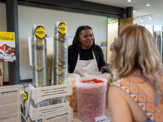 Tashir B., in action., with students serving his popcorn blend from his small business, The Ballard Bakery.