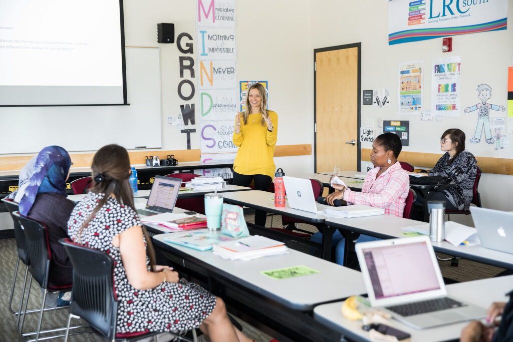 A Rowan University education graduate leads a discussion for master's of science in teaching candidates in a brightly colored classroom. 