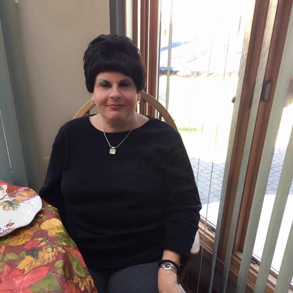 Mom Joyce sits at her kitchen table.