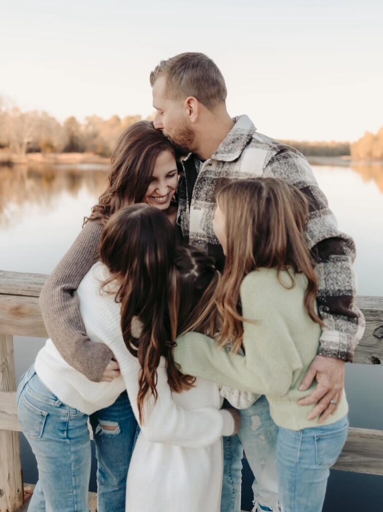 Rowan Online student, Gabrielle F., hugs her family outdoors.