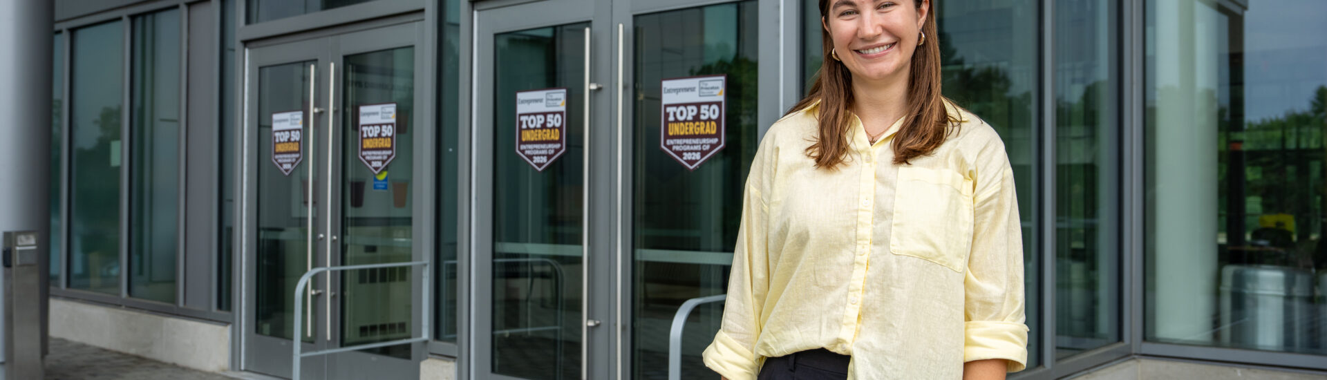Marketing and entrepreneurship alumna Megan S. smiling outside Rowan University’s William G. Rohrer College of Business.
